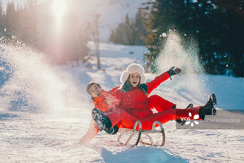 快乐的夫妇滑雪橇在冬季假期图片素材