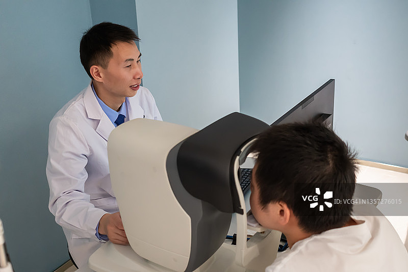一位亚洲眼科医生正在检查病人的眼睛图片素材