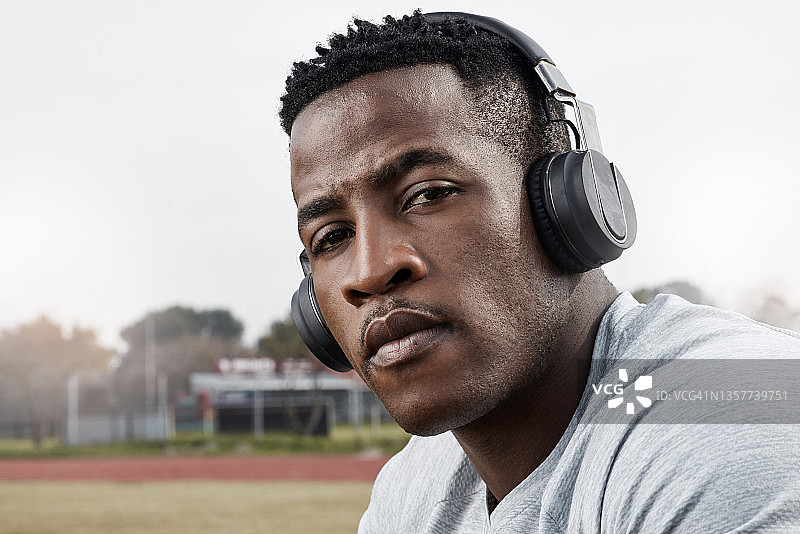 一个运动的年轻人戴着耳机外出锻炼图片素材