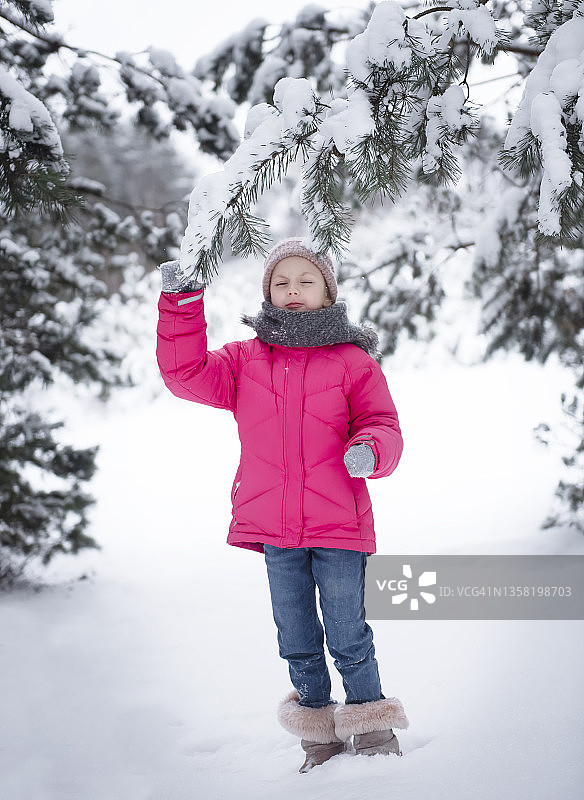 孩子在冬天。一个小女孩，在冬天的外面玩耍。图片素材