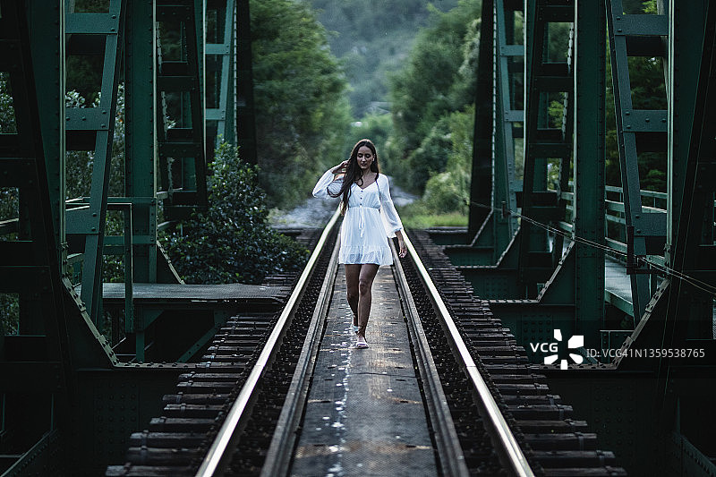 年轻女子走在铁路桥上图片素材