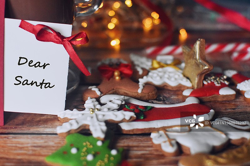 木桌上有姜饼、写有“亲爱的圣诞老人”文字的圣诞贺卡和一杯热可可图片素材