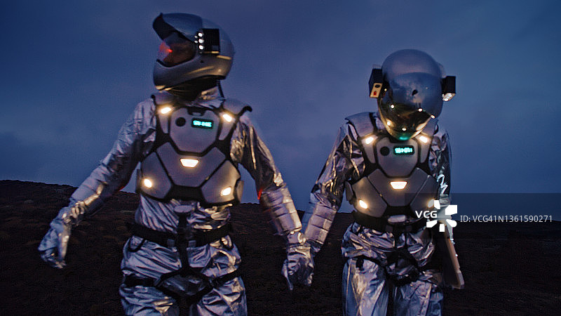 自拍太棒了。宇航员们穿着未来派的、发光的宇航服，手拉着手拍照图片素材