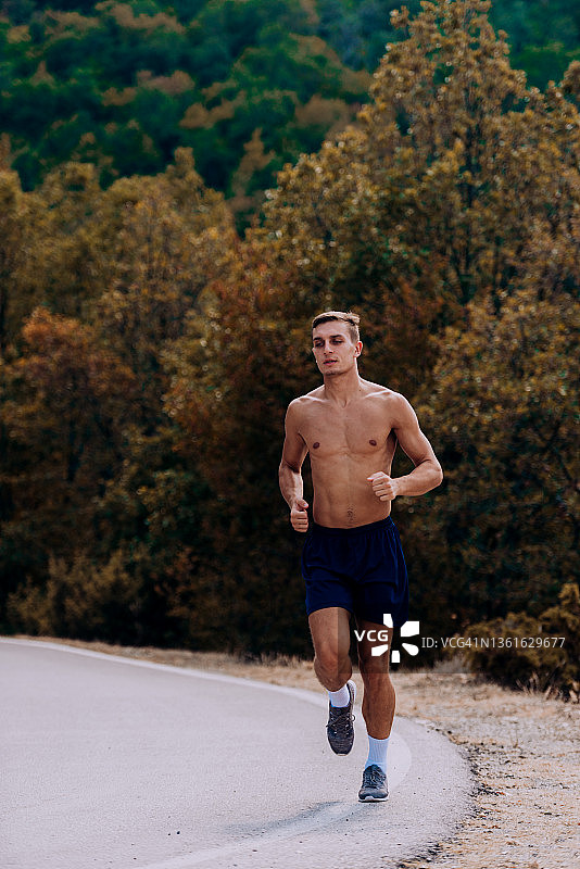 一名健康的男子在山路上跑步的全身像图片素材