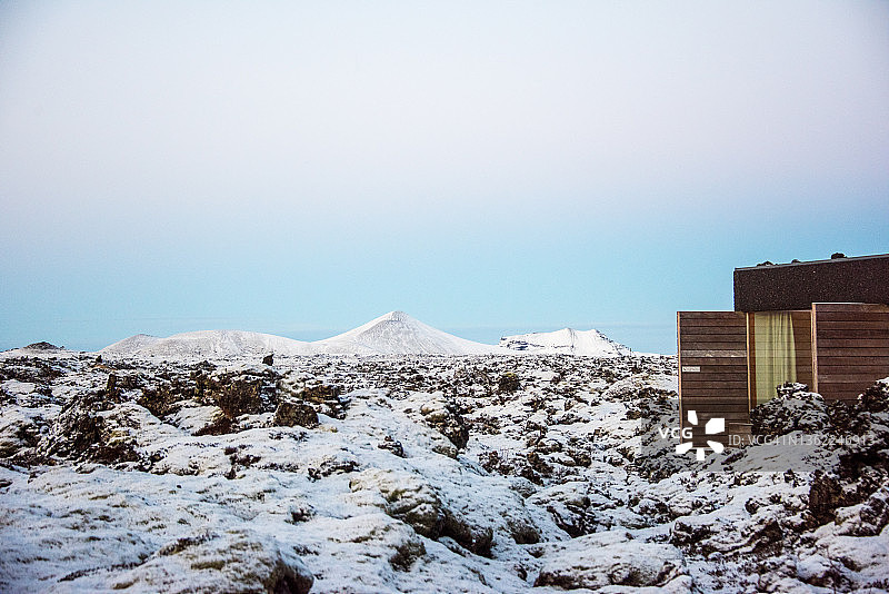 火山熔岩覆盖着白雪和小木屋图片素材