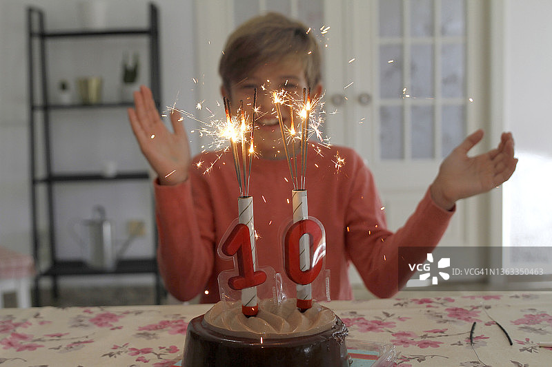 吹生日蛋糕上的蜡烛的男孩图片素材