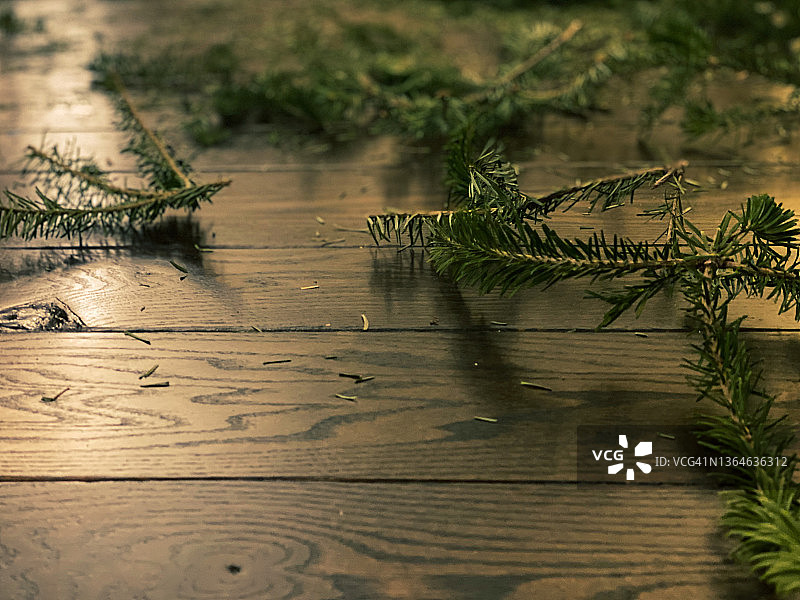 看到绿色:移走家里的圣诞树后，落在硬木地板上的松针和树枝图片素材