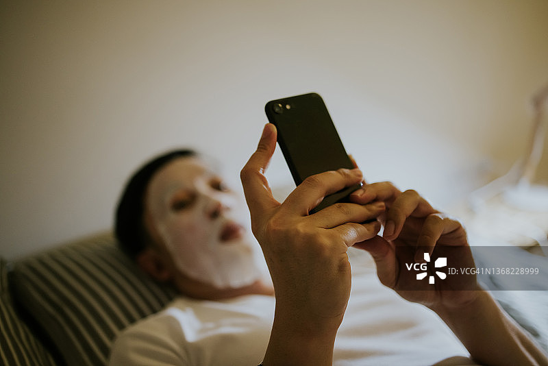 选择性聚焦美容水疗中心，35岁以上男性睡前使用电话进行保健图片素材