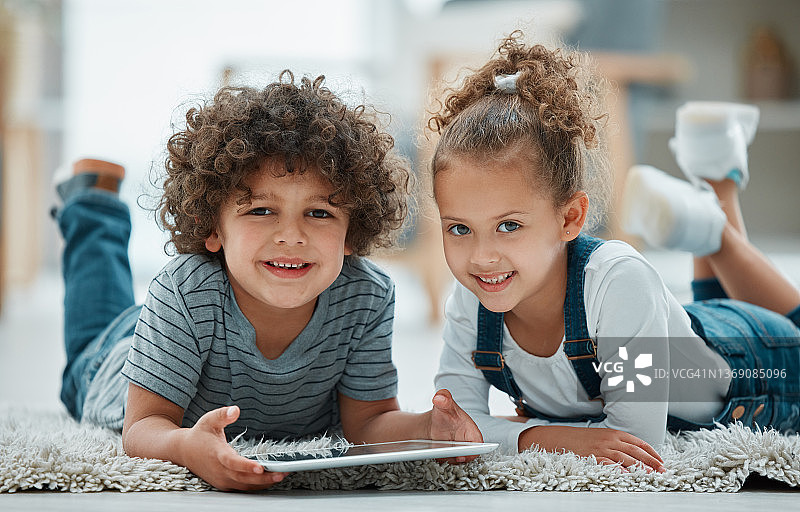 两个兄弟姐妹一起玩平板电脑的照片图片素材