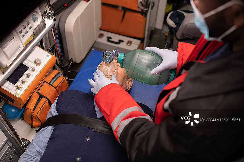 救护人员在救护车中使用氧贮器图片素材