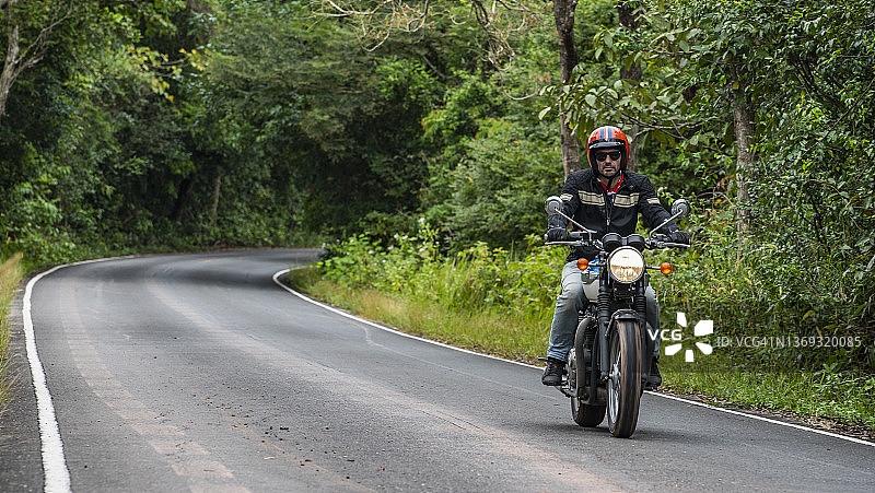 一名男子在考艾国家公园骑着他的经典摩托车图片素材