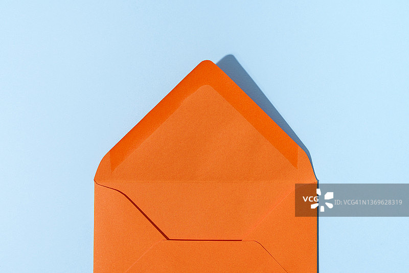 打开的蓝色背景的橙色信封图片素材