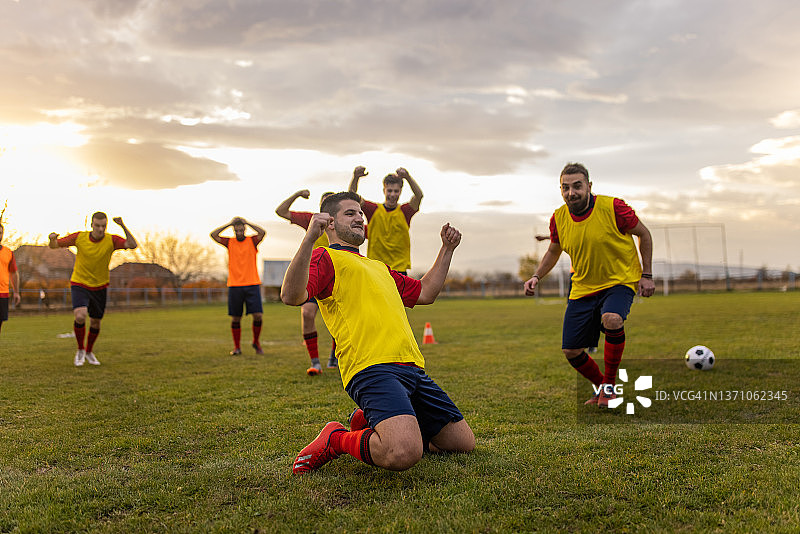 身穿黄色反射衫的足球队兴奋不已，庆祝足球比赛的胜利图片素材