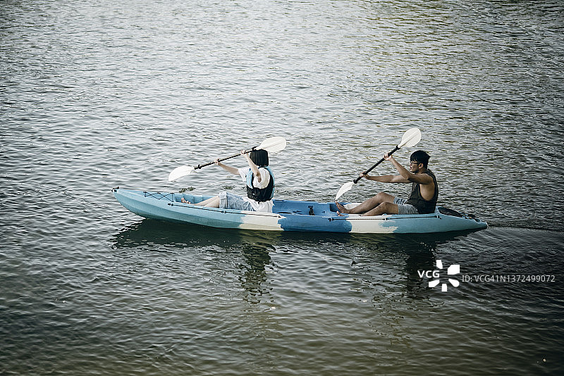 一对亚洲家庭的兄弟姐妹享受和休闲皮划艇河边周末活动图片素材