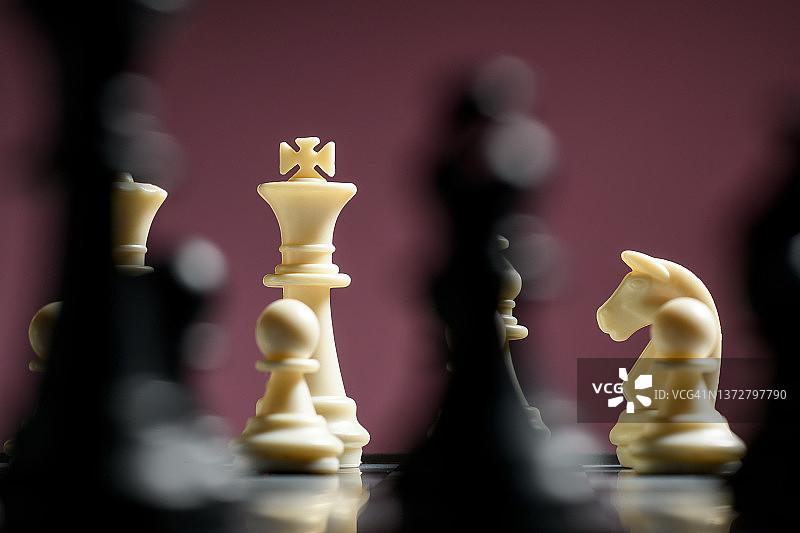 棋盘上象棋棋子的特写对栗色背景图片素材