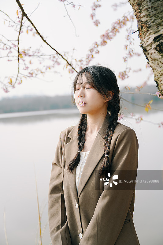 美丽的亚洲女孩在樱桃树下图片素材