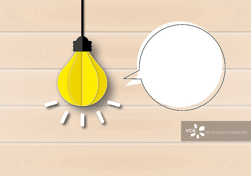 发光的灯泡与阴影和言语泡泡在木制背景上，概念创新思维创新。图片素材