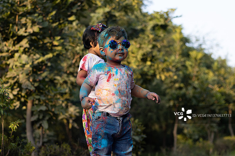 快乐的亚洲印度孩子男孩和女孩享受节日的颜色与胡里彩粉称为古拉尔图片素材