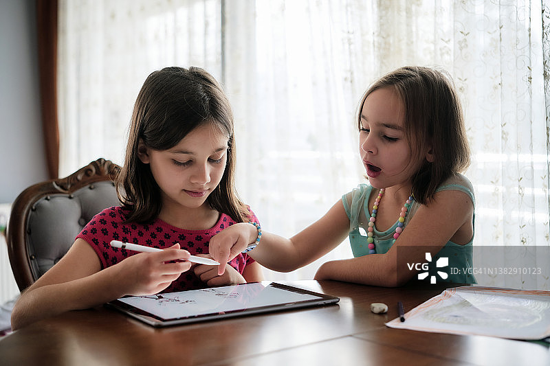 孩子们在家里用数码笔在数码平板上画画图片素材
