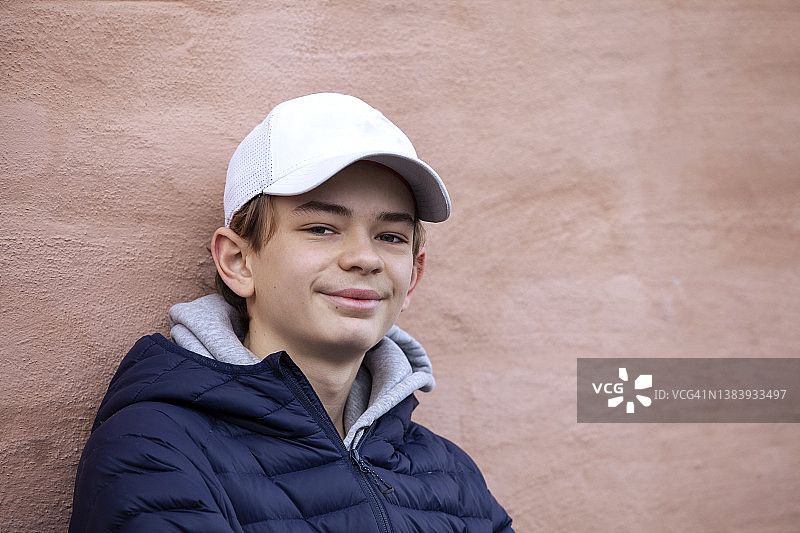微笑的少年在棒球帽的肖像图片素材