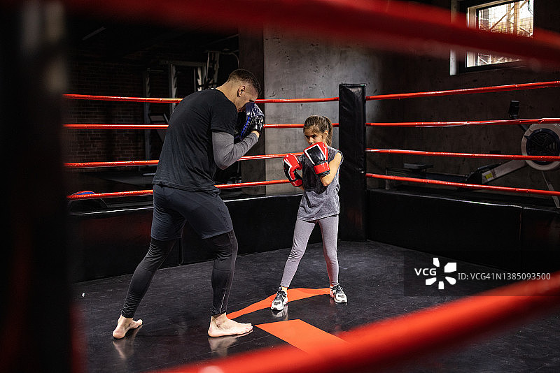 强壮的小女孩和她的男教练在健身俱乐部练习跆拳道图片素材