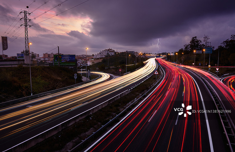 车灯在雷声隆隆的繁忙高速公路上留下痕迹图片素材