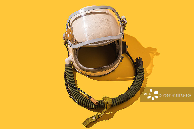 黄色背景的复古乌克兰宇航员头盔。飞行、飞行员、空间、探索和幻想概念。图片素材