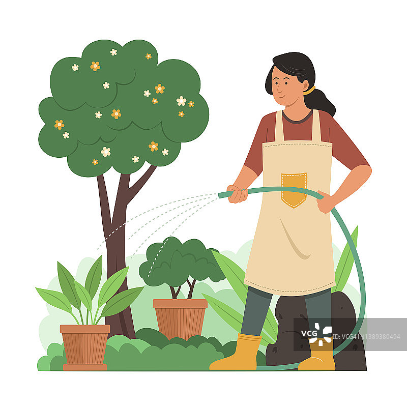 在花园里给植物浇水的女人。图片素材