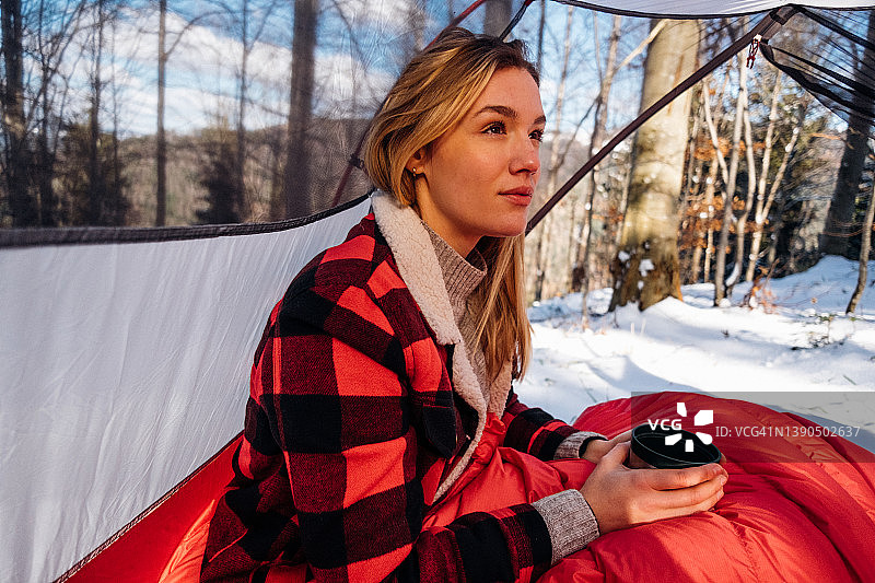 冬天在帐篷里用旅行杯的女人图片素材