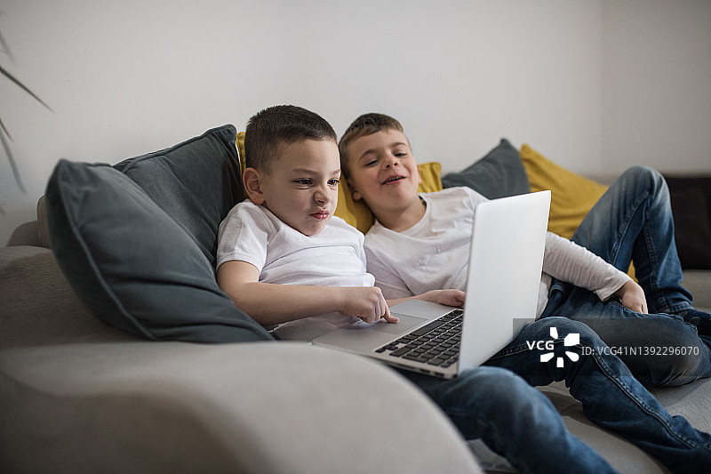 两个孩子在家里用笔记本电脑图片素材