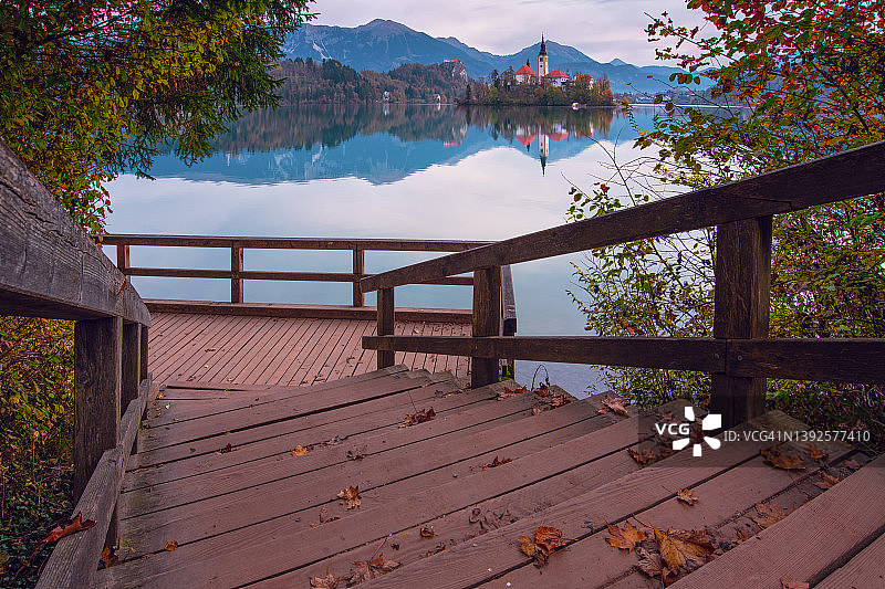 斯洛文尼亚的流血湖。木制台阶，前景是秋天的树叶图片素材