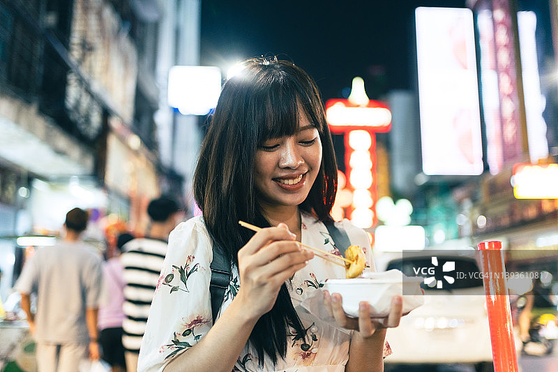 年轻的亚洲女子享受各种街头食品在曼谷唐人街的曼谷，泰国曼谷。图片素材