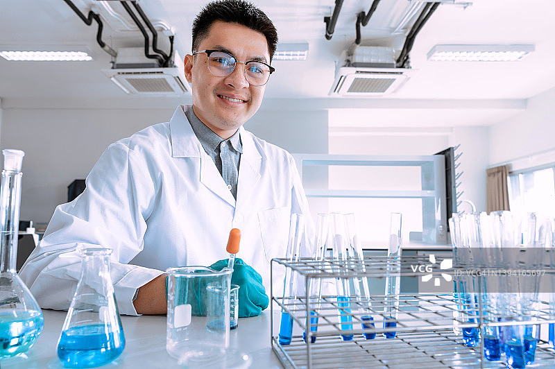 在实验室工作的年轻亚洲男性科学家的肖像。医生和科学家在实验室工作的冠状病毒大流行，covid - 19的概念图片素材