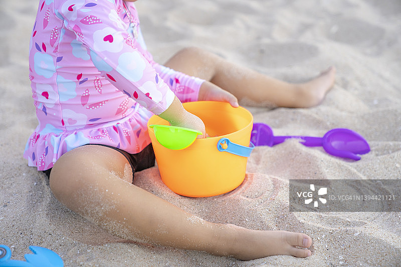 小女孩在沙滩上玩沙子的一部分图片素材