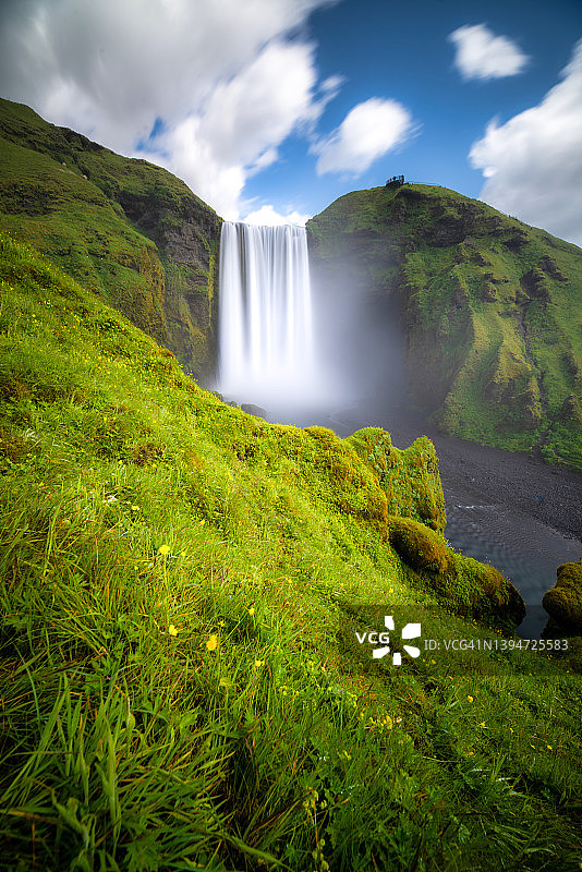 夏日的冰岛，蓝天下的斯科加福斯瀑布。Skógafoss瀑布是冰岛中南部旅游的热门景点之一。图片素材