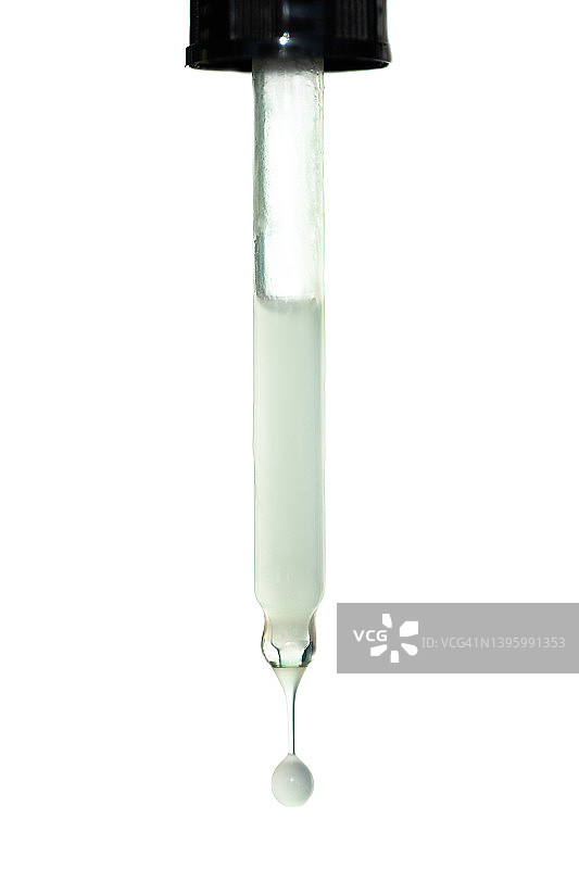 一滴白色的保湿乳液从白色的背景上的玻璃吸管滴下来。美容程序和身体护理的概念。聚谷氨酸是一种新型透明质酸。微距摄影图片素材