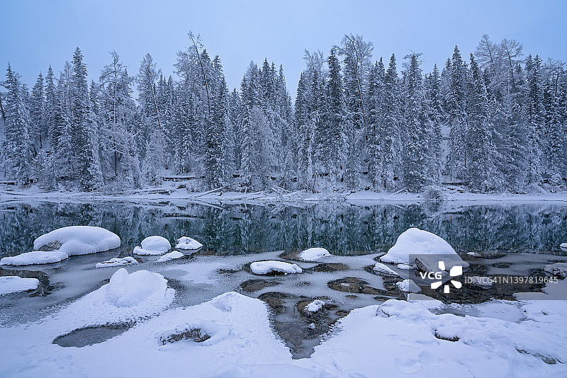 雪覆盖着湖边的石头图片素材