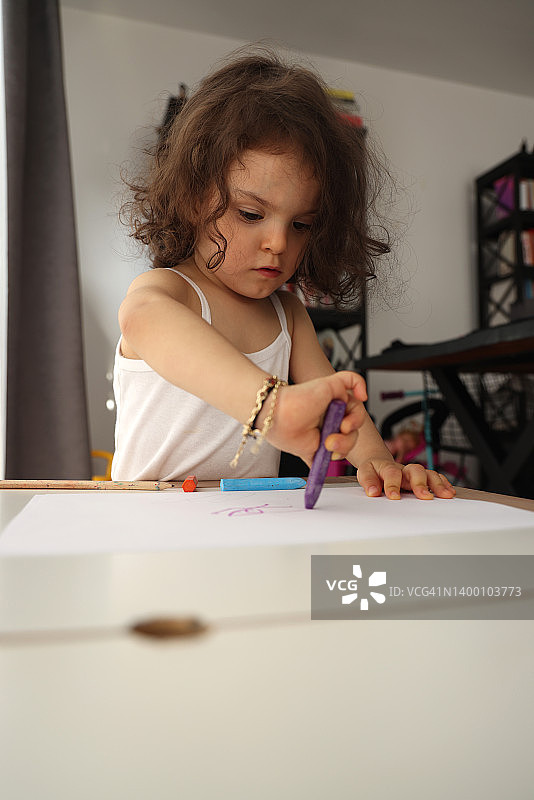 小女孩用彩色铅笔画画。图片素材