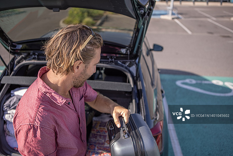 一个人在整理他的电动汽车的后备箱图片素材