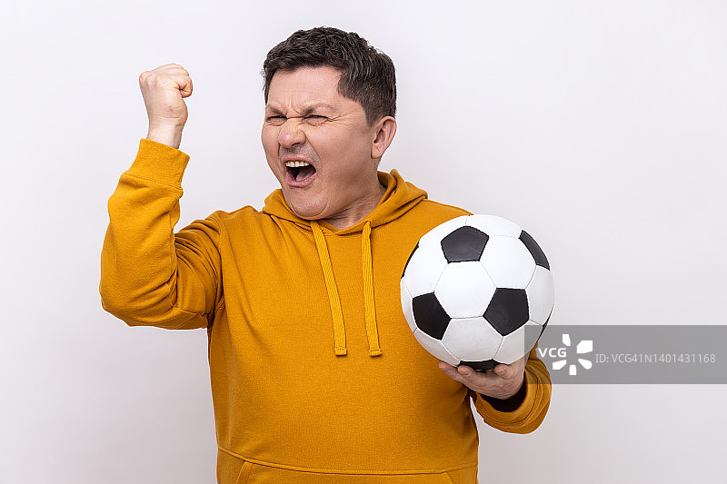一名男子手持足球尖叫，庆祝最喜爱的足球队赢得冠军图片素材