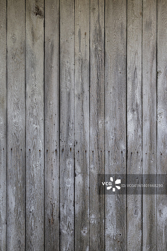 一堵古老的、风化的、老化的木墙的正面视图。图片素材