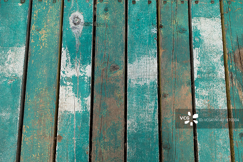 有绳结的旧蓝色或青绿色木板木质结构，有质感的彩绘背景。一面油漆褪色剥落的旧横幅。码头上明亮褪色的木制平台或甲板。图片素材