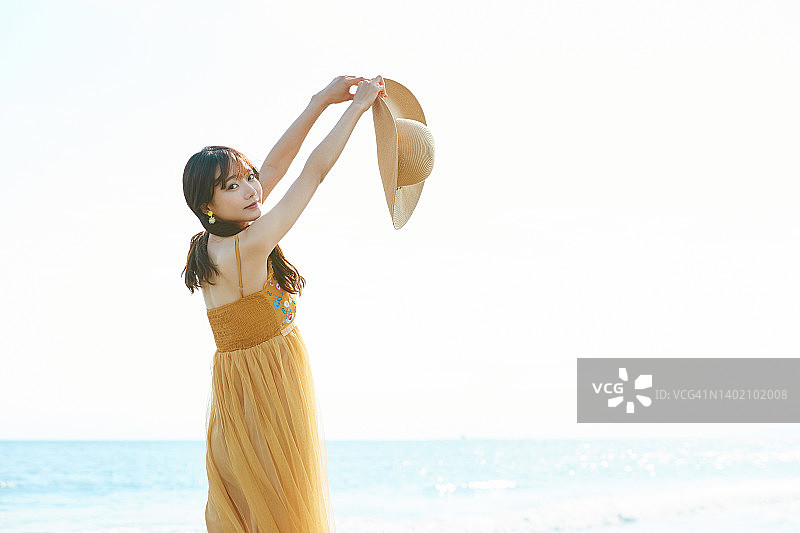 年轻的亚洲女子在海滩上享受度假图片素材