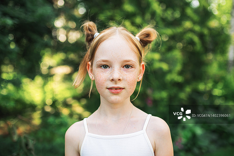 肖像红头发的女孩与雀斑在夏天模糊的背景。快乐快乐的童年图片素材