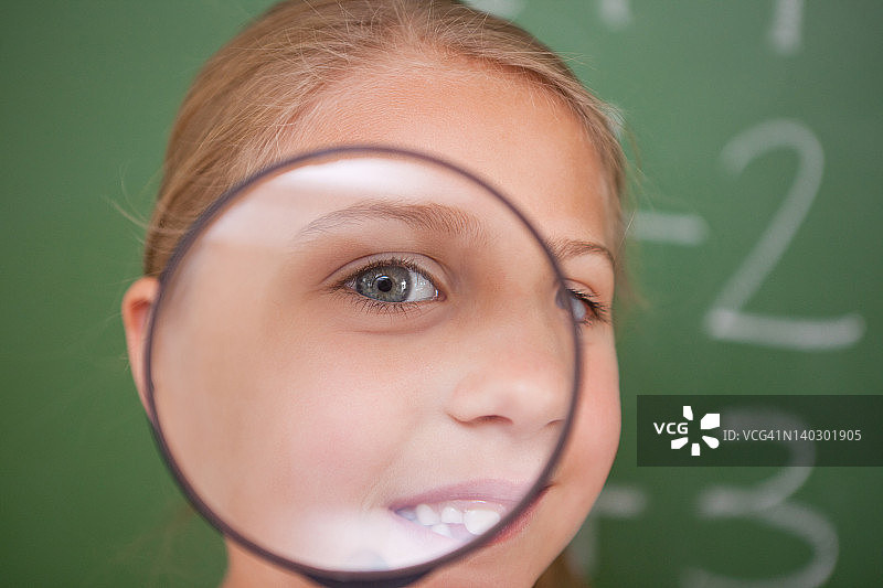 一个女学生通过放大镜看的特写图片素材