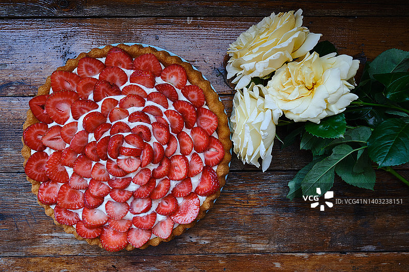 木制背景的美味草莓馅饼。甜糕点配新鲜浆果。茶点和节日甜点图片素材