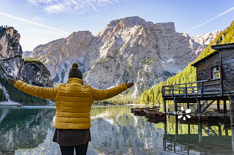 女游客享受与手臂在高山湖泊图片素材