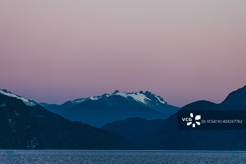 日落时湖边的山脉。智利巴塔哥尼亚的夏夜图片素材