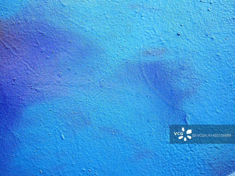 法国巴黎，有纹理的混凝土墙被涂成蓝色，被阳光照亮图片素材