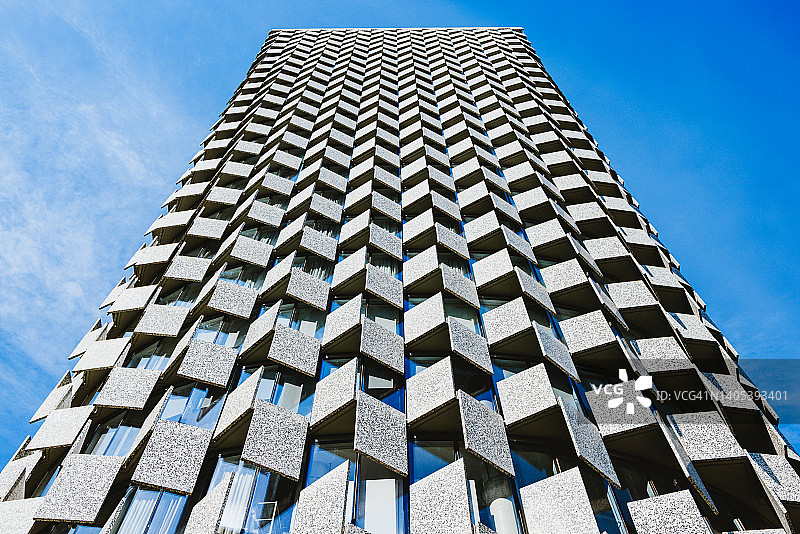 建筑外观的低角度视角，混凝土面板和窗户朝向蓝天图片素材